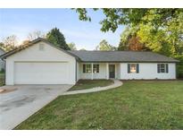 Charming single-story home featuring a manicured lawn, attached garage, and classic vinyl siding at 175 Cypress Dr, Covington, GA 30016