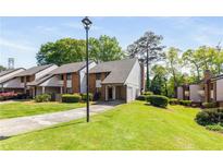 Inviting townhome featuring manicured lawn, mature trees and convenient covered parking at 3228 Clairmont North Ne # 3228-A, Brookhaven, GA 30329
