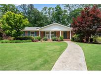 Charming brick home with lush landscaping, manicured lawn and a welcoming walkway at 2310 Kings Point Dr, Atlanta, GA 30338