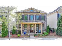 Charming two-story home with a welcoming front porch, beautiful landscaping, and meticulous yard at 6425 Bellmoore Park Ln, Johns Creek, GA 30097