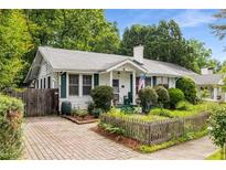 Charming home with brick driveway, walkway, well-kept landscaping and inviting covered front porch at 4 Arc Ne Way, Atlanta, GA 30305