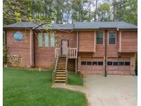 Charming home featuring wood siding, a two-car garage, and a neatly maintained front yard at 4020 Cranwood Dr, Atlanta, GA 30349