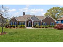 Charming brick home with well-manicured lawn, blue shutters, and a welcoming front entrance at 7425 Twin Creek Ct, Cumming, GA 30041