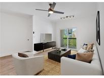 Bright living room features a ceiling fan, modern furniture, and a sliding glass door leading to the outside at 1075 Peachtree Ne Walk # A421, Atlanta, GA 30309