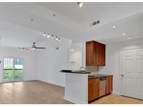 Bright living room and kitchen area features hardwood floors, granite countertops, stainless steel appliances, and a balcony at 1075 Peachtree Ne Walk # A421, Atlanta, GA 30309