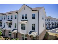 New townhome with white siding, brick accents, black awnings, and large windows at 1263 Harvest Park Ln, Suwanee, GA 30024