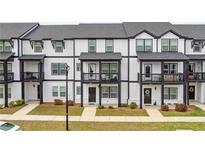 Modern townhome exteriors showcase black trim, balconies and manicured lawns at 823 Mackay Crk, Woodstock, GA 30188