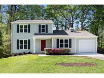 Charming two-story home with a well-maintained lawn, a red front door and lush landscaping at 2965 Carrie Farm Nw Rd, Kennesaw, GA 30144