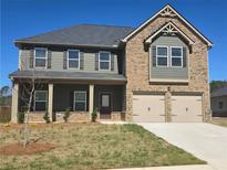 Charming two-story home with a brick and siding facade, complemented by a two-car garage and well-manicured lawn at 1636 Fuma Leaf Way, Mcdonough, GA 30253