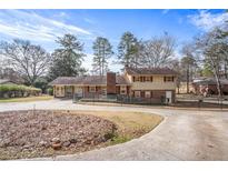 Charming two-story home featuring a brick chimney, red shutters, and a fenced yard at 7121 Forest Se Dr, Covington, GA 30014
