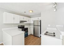 Bright kitchen featuring stainless steel appliances, white cabinetry, and modern countertops at 1066 Rock Creek Ln, Norcross, GA 30093