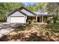 Charming single-story home featuring a front lawn, two-car garage, and covered front entry at 11268 Flat Shoals Rd, Covington, GA 30016