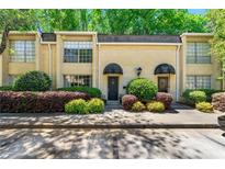 Charming townhome featuring a manicured front yard and a classic brick facade with black awnings above the entries at 5400 Roswell Rd # J2, Atlanta, GA 30342