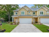 Charming townhouse featuring a well-manicured lawn, attached garage, and inviting facade at 6860 Robinson St, Lithonia, GA 30058