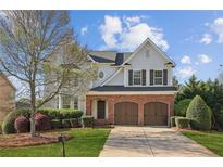 Charming two-story home featuring a brick facade, attached two-car garage, landscaped front yard, and a welcoming entrance at 3465 Caney Creek Ln, Cumming, GA 30041