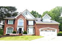 Beautiful brick home with attached garage, arched window and manicured front yard at 1081 Talon Trce, Lawrenceville, GA 30043