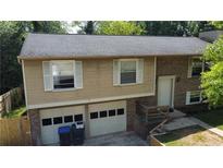 Inviting two-story home features a two-car garage, brick accents, and a neatly maintained front yard at 1425 Parkmont Dr, Roswell, GA 30076