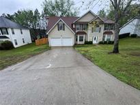 Charming two-story home featuring a two-car garage, well-maintained lawn, and inviting front entrance at 3472 Riverview Chase Way, Ellenwood, GA 30294