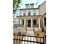 Beautiful light brick two story home features a welcoming front porch and black wrought iron fencing at 1059 Dryden Ln # 11, Atlanta, GA 30319