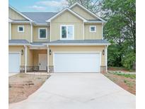 Charming two-story townhome with a spacious two-car garage and well-manicured lawn at 6884 Robinson St, Lithonia, GA 30058