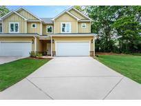 Charming new construction townhouse with a two-car garage, manicured lawn, and inviting curb appeal at 6884 Robinson St, Lithonia, GA 30058