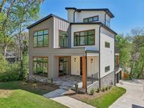 Striking modern home with mixed siding, large windows, and a stone porch, set amidst a lush green lawn at , Atlanta, GA 30310