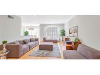 Bright living room with hardwood floors, modern furnishings, and large windows for natural light at 200 Renaissance Ne Pkwy # 219, Atlanta, GA 30308