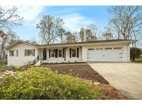 Charming one-story home with a two-car garage, black shutters, and manicured landscaping at 4646 Mountain Creek Ne Dr, Roswell, GA 30075