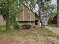 Charming two-story home with a well-maintained front yard and mature trees at 6301 Creekford Dr, Lithonia, GA 30058