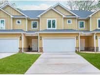 Charming yellow townhomes feature attached garages, stone accents, and well-manicured lawns at 6880 Robinson St, Lithonia, GA 30058