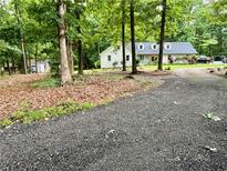 Charming home with a blue door, surrounded by lush trees and a long driveway at 527 Gaddis Rd, Canton, GA 30115