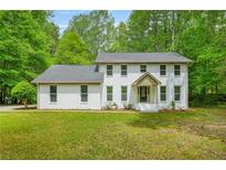 Charming two-story home with a white painted brick exterior and lush green lawn at 230 Deer Forest Rd, Fayetteville, GA 30214