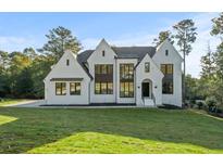 Stunning white painted home with black trim and modern windows on a lush green lawn at 584 Indian Hills Pkwy, Marietta, GA 30068
