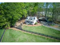 Charming home featuring a large, grassy yard, a quaint front porch, and a convenient carport at 8132 Union Hill Rd, Canton, GA 30115