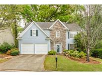 Charming two-story home with stone accents, lush landscaping, and a well-manicured lawn at 4034 Brockett Walk, Tucker, GA 30084