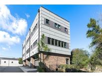 Modern townhome featuring a brick facade and architectural paneling, complemented by professional landscaping and mature trees at 611 King Arnold St, Atlanta, GA 30354