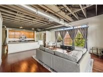 Open-concept living room with hardwood floors, exposed ceiling, and large windows providing natural light at 791 Wylie Se St # 102, Atlanta, GA 30312