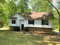 Charming single-Gathering home with a well-maintained lawn and mature trees creating a private, wooded setting at 997 Timbervale Ln, Lithonia, GA 30058