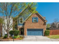 Charming two-story brick home with blue accents, a well-manicured lawn, and a two-car garage at 2075 Old Georgian Nw Ter, Atlanta, GA 30318