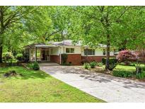 Charming single-story home with a brick facade, covered carport and a long driveway lined with mature trees at 3800 Whitaker Ln, Lithia Springs, GA 30122