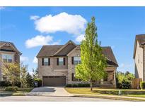 Charming two-story brick home featuring a well-manicured lawn and attached garage at 1285 Brynhill Ct, Buford, GA 30518