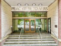 The Peachtree Towers entrance has stone steps and a glass door leading into the building at 300 Peachtree Ne St # 21H, Atlanta, GA 30308
