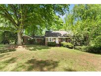 Charming brick home with lush green lawn and mature trees at 4300 Valley Trail Dr, Atlanta, GA 30339
