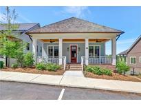 Charming home featuring a welcoming front porch with classic columns and a well-manicured lawn at 1130 Lupo Loop, Chattahoochee Hills, GA 30268