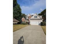 Traditional two-story home with a brick and siding exterior, two-car garage, and well-manicured landscaping at 2012 Grove Park Ct, Marietta, GA 30062