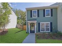 Charming two-story townhouse featuring light-green siding, black shutters, and a well-maintained front lawn at 1021 Windy Oaks Se Ct, Smyrna, GA 30080