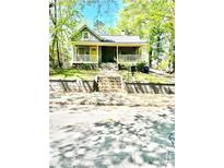 Charming home featuring a welcoming front porch, complemented by verdant landscaping and stone steps at 635 Sw Queen Sw St, Atlanta, GA 30310