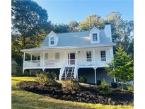 Charming two-story white home featuring a welcoming front porch and well-manicured landscaping at 102 Collins Way, Douglasville, GA 30134