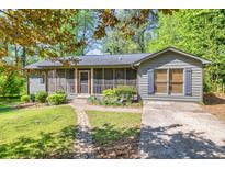 Charming home with a screened front porch, stone walkway, and beautifully landscaped front yard at 1878 Suwanee Roberts Ct, Lawrenceville, GA 30043
