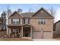 Charming two-story brick home featuring a covered front porch and attached two-car garage at 180 Cleburne, Acworth, GA 30101